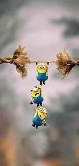 Minions hanging playfully from a rope in cartoon wallpaper scene.