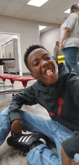 Boy joyfully posing in a cafeteria setting.