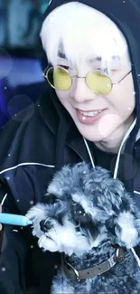 Person in hoodie with glasses smiling at fluffy dog.