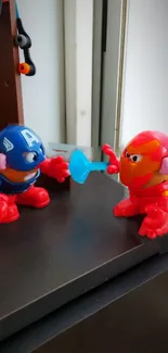 Two toy figures resembling superheroes in a playful battle scene.