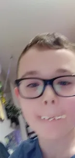 A young boy with glasses eats a snack playfully indoors.