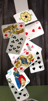 Falling poker playing cards on a wooden background.