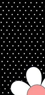 Black polka dot wallpaper with a white flower accent.