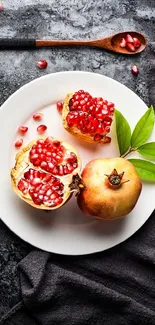 Pomegranate and leaves on white plate with dark cloth background.