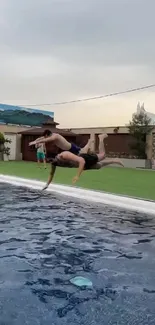 Two individuals diving into a pool on a summer day.