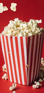Red and white popcorn box on red background.