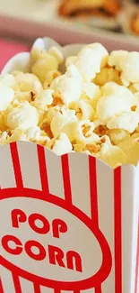 A close-up of popcorn in a red-striped box.