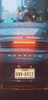 Porsche 911 Carrera on a rainy city street, beautifully captured.