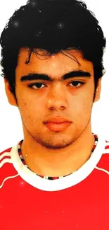 Portrait of a young man in a red sports shirt on a neutral background.