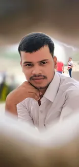 Soft focus portrait of a man in a white shirt with a serene expression.