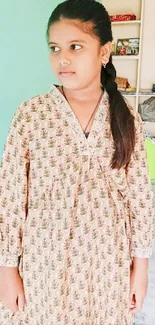 Portrait of a young girl in floral dress indoors.