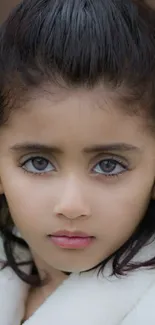 Close-up portrait of a young girl with captivating eyes for mobile wallpaper.