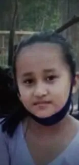 A portrait of a young girl with a calm expression outdoors.