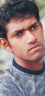 Portrait of a young man with a patterned shirt and thoughtful expression.