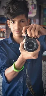 Young man holding a camera in a vibrant indoor portrait setting.