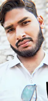 Portrait of a bearded man against a brick wall.