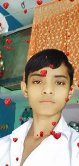 Young person posing indoors with colorful orange curtain.