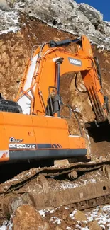 Orange excavator in rocky landscape.