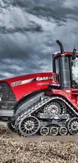 Vivid red tractor in a field under a stormy sky.