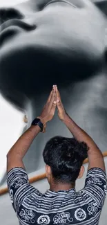 Person praying before a large statue, creating a serene visual.