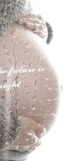 Pregnant belly with inspiring message: 'the future is bright' in cozy setting.