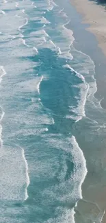 Aerial view of turquoise ocean waves on a pristine sandy beach.