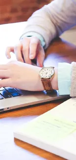 Hands typing on laptop at a tidy workspace desk.
