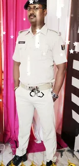 A confident officer in uniform stands against a bright pink backdrop.