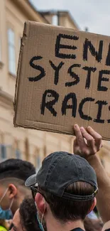 Diverse crowd holding protest signs against systemic racism.