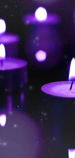 Purple candles glowing softly with reflections.