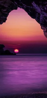 Purple sunset through cave entrance on beach.