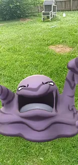 Purple creature on green grass in outdoor setting.