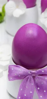 Vibrant purple Easter egg with bow in white setting.