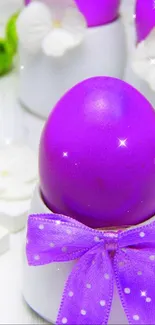 Purple Easter egg decorated with white ornaments and tied with a bow.