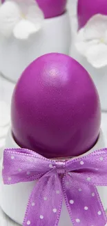 Vibrant purple Easter egg with a lavender bow in a white holder.