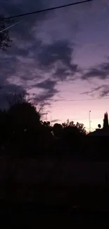 Dark silhouette against purple evening sky with clouds