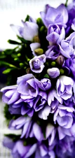 Beautiful purple floral bouquet on a textured surface.