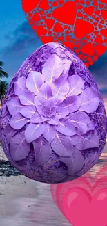 Purple floral egg on a beach with red hearts.