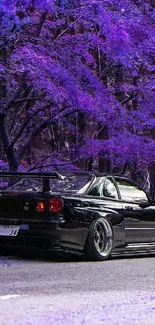 Black sports car in purple forest setting.