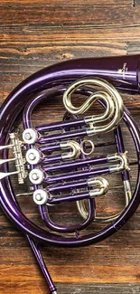 Purple French horn on brown wooden surface.