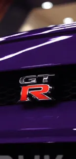 Close-up of a purple GT car emblem on a sports vehicle.