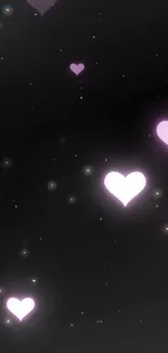 Mobile wallpaper with glowing purple hearts against a black night sky.
