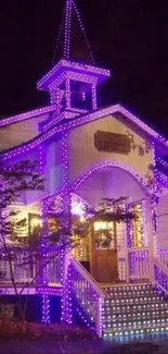 Chapel with vibrant purple lights at night.