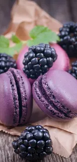 Purple macarons paired with blackberries on a rustic surface.