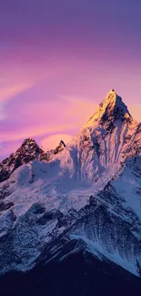 Snow-capped mountain under a glowing purple sky during evening.