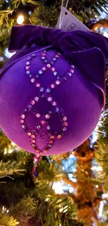 Purple ornament with rhinestones on a Christmas tree.