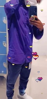 Person in a purple outfit with pixel hearts on a mobile wallpaper.