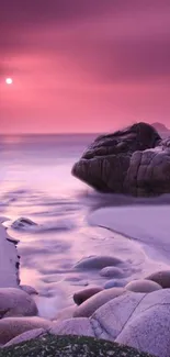 Purple sunset over rocky coastline with soft waves and serene hues.