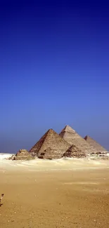 Stunning wallpaper of Pyramids under a vast blue desert sky.