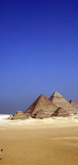 Majestic pyramids under a vibrant blue sky in the desert, perfect for mobile wallpaper.